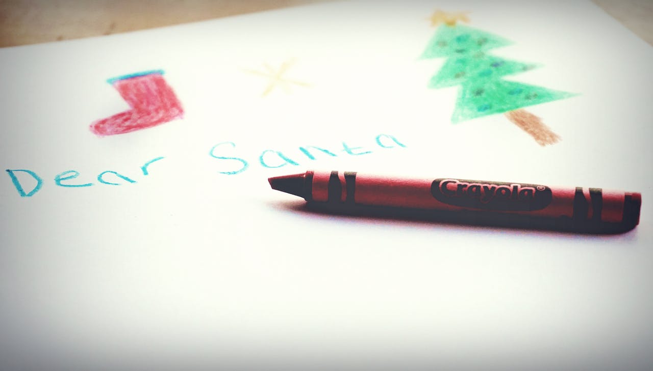 A festive child's drawing featuring Christmas symbols and a Crayola crayon.