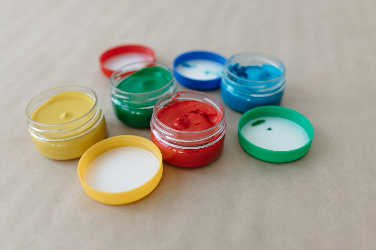 about-01 Vibrant paint jars with primary colors for art and creativity. Perfect for painting classes.